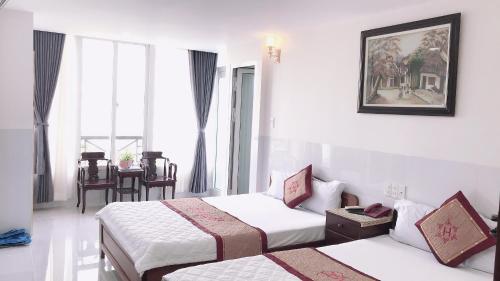 a hotel room with two beds and a couch at Hoang Son Hotel in Nha Trang