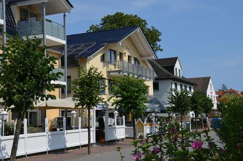 een rij huizen op een straat met bomen bij Apartment-Seemoewe-1A-Standlage-nur-150m-mit-Parkplatz in Baabe