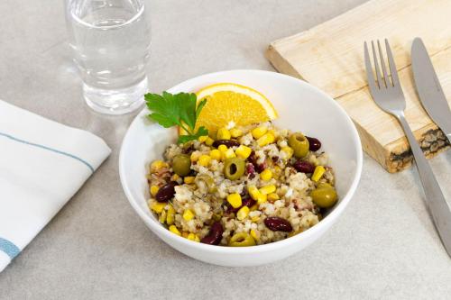 a bowl of cousridge with olives and corn and an orange slice at Zenitude Hôtel-Résidences Narbonne Centre in Narbonne