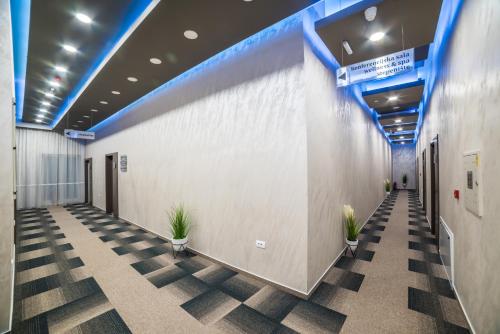 a hallway in a building with potted plants at Hotel River in Bijeljina