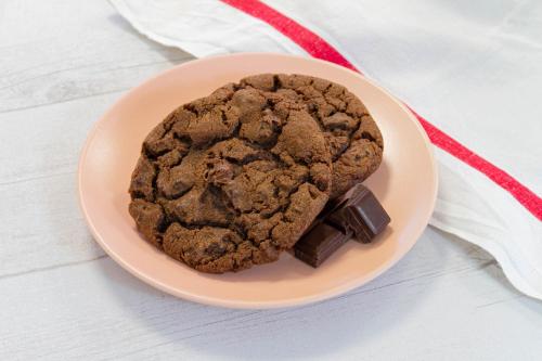 a chocolate cookie on a plate with a red ribbon at Zenitude Hôtel-Résidences Narbonne Centre in Narbonne