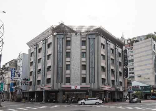 a large building on a city street with a car at Raise Hotel Taichung in Taichung