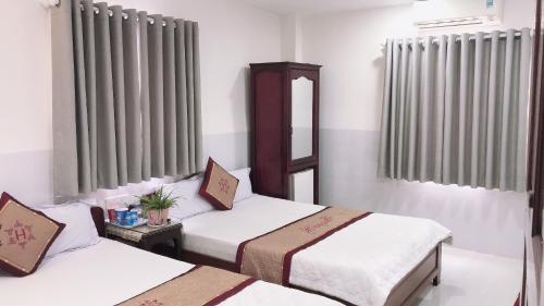 a hotel room with two beds and a mirror at Hoang Son Hotel in Nha Trang