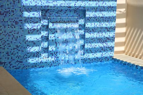 a swimming pool with a water fountain in it at Simaisma A Murwab Resort in Sumaysimah