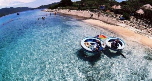 two people in boats in the water on a beach at Hoang Son Hotel in Nha Trang