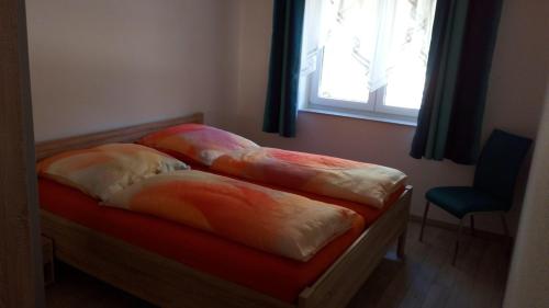 two pillows on a bed in a room with a window at Haus-Hempel-1 in Groß Mohrdorf