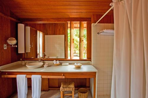 a bathroom with a sink and a mirror at Hotel Vila Naià - Corumbau in Corumbau