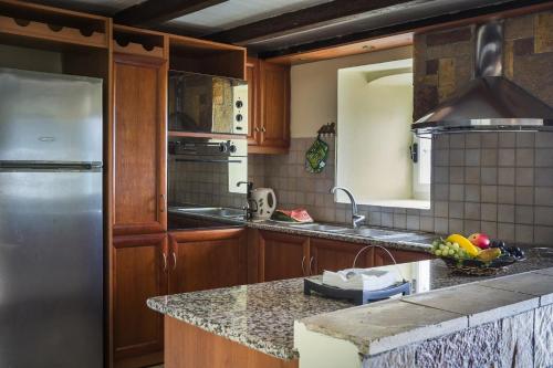 a kitchen with a stainless steel refrigerator and granite counter tops at Villa Fantastic View in Khalikerí