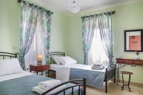a bedroom with two beds and a window with curtains at Villa Fantastic View in Khalikerí