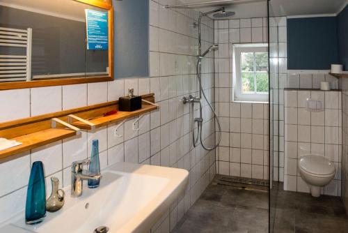 a bathroom with a sink and a shower at Schoenes-Ferienhaus-mit-Garten-Mid-Century-Moebeln-in-Strand-naehe-Avendorf in Avendorf auf Fehmarn