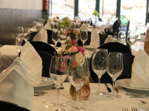 a table with wine glasses and flowers on it at Hotel Fonte da Vila in Monção