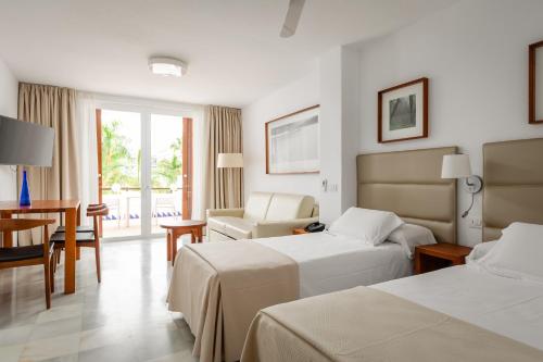 een hotelkamer met 2 bedden en een bureau bij Apartments Parque Santiago IV in Playa de las Americas