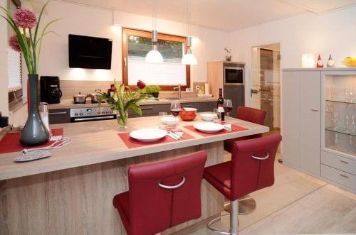 a kitchen with a table and red chairs in a kitchen at Ferienwohnung-Marion in Ennepetal