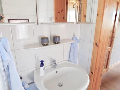 y baño con lavabo blanco y espejo. en Haus-Scheel, en Burg auf Fehmarn