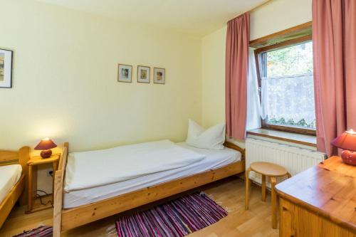 a bedroom with a bed and a desk and a window at Wohnung 5 Morgensonne in Hergensweiler