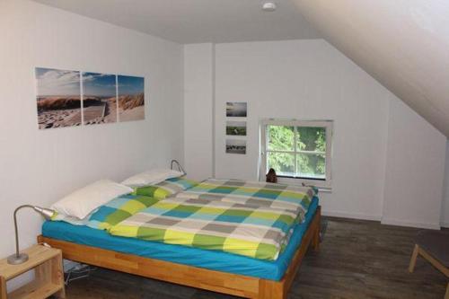 um quarto com uma cama num quarto branco em Luettje-Auszeit em Dornum