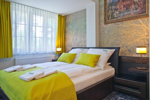 sypialnia z dużym łóżkiem z żółtymi poduszkami w obiekcie WISŁA Cechini w mieście Krynica Zdrój
