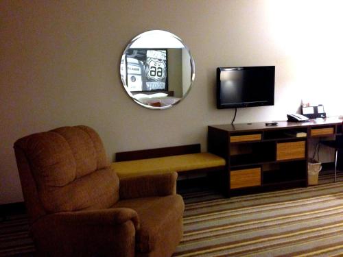 a living room with a chair and a mirror at Super 8 by Wyndham Stafford/Springfield Area in Strafford