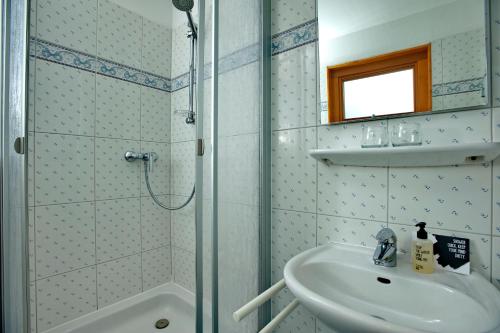 un baño con lavabo y ducha en Bungalow-L, en Westerland