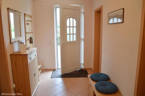 einen Flur mit Tür und zwei Hockern in einem Zimmer in der Unterkunft Ferienwohnung "  An der Koppel " in Mölln-Medow