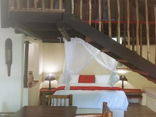 a bedroom with a bed in a room with a staircase at Pumusa Bushcamp in Hluhluwe