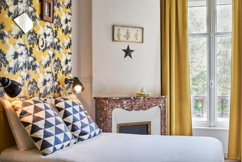 um quarto com uma cama e uma lareira em Hôtel Stanley by HappyCulture em Nancy