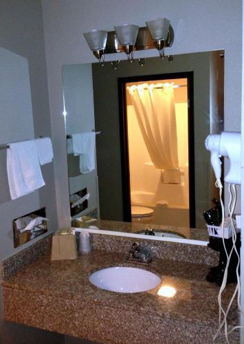 a bathroom with a sink and a large mirror at Super 8 by Wyndham Stafford/Springfield Area in Strafford
