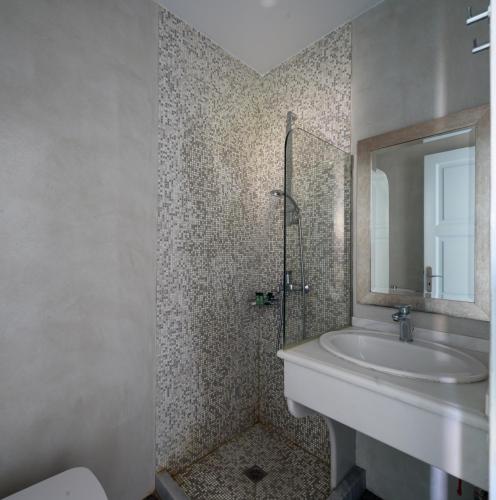 a bathroom with a sink and a mirror at Alesahne Beach Hotel in Kamari