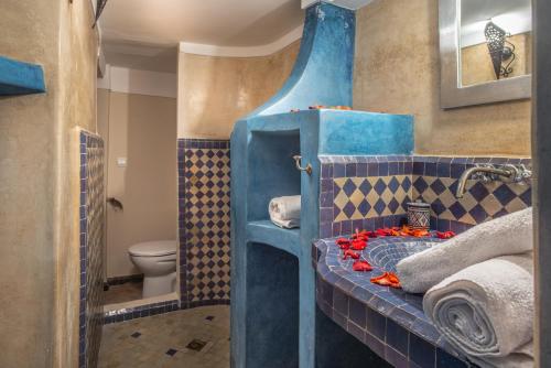 bagno blu con servizi igienici e lavandino di Riad Dar Sirine a Marrakech