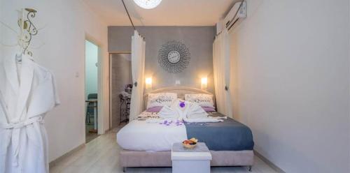 a bedroom with a bed with white and purple pillows at Magic Touch in Shlomi