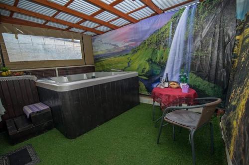a bathroom with a bath tub and a table with a red table cloth at Magic Touch in Shlomi