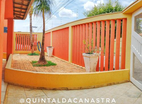 uma cerca laranja com uma palmeira num pátio em Casa com piscina - 3 quartos - Centro em São João Batista do Glória