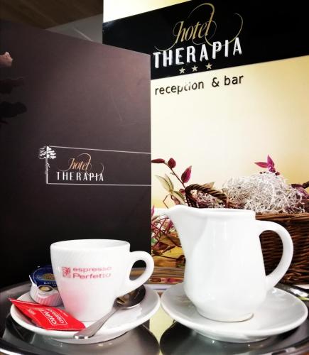 two white cups and saucers on a table at Hotel Therapia in Pécs