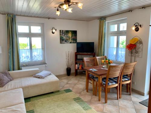 sala de estar con mesa y sofá en Villa-Rosengarten-Ferienwohnung-Terra en Sassnitz