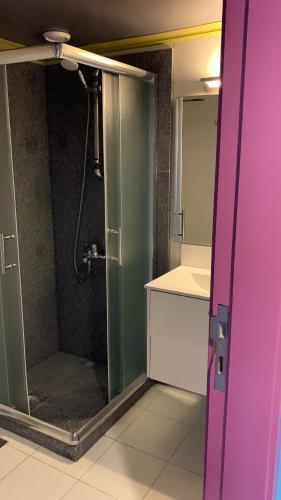 a bathroom with a shower with a glass door at L'Hotel De Mon Pere in Jbeil