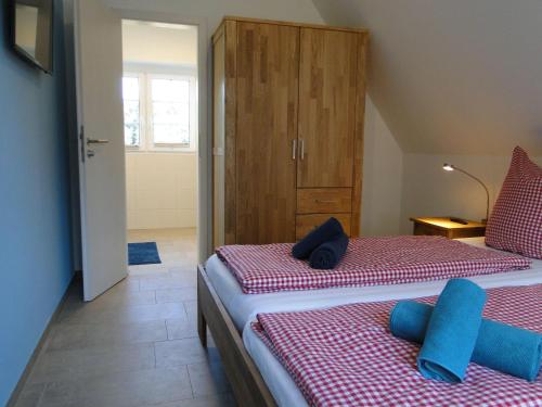 ビスピンゲンにあるBispinger-Heidezauber-Haus-Hartriegelのベッドルーム1室(ベッド2台、木製キャビネット付)