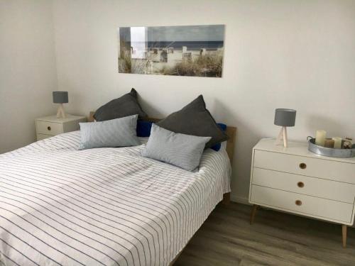 um quarto com uma cama com duas almofadas e uma cómoda em MEHS46A21-FeWo-Best-Kiekout em Meeschendorf