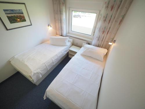 ein kleines Zimmer mit zwei Betten und einem Fenster in der Unterkunft Appartement 6 in Westerland