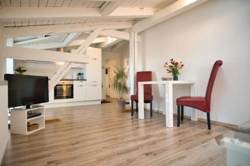 a living room with a table and chairs and a tv at Haus Steuerrad in Stralsund