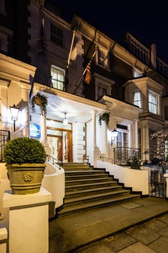 a building with stairs and a potted plant in front at Best Western Swiss Cottage Hotel in London