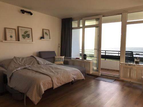 a bedroom with a bed and a view of the ocean at Beachhouse-Staberdorf in Staberdorf