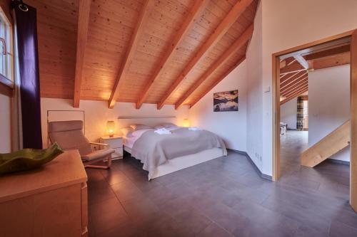 a bedroom with a bed and a chair in a room at Apartment Staubbach, Best views, Spacious, Family friendly in Lauterbrunnen
