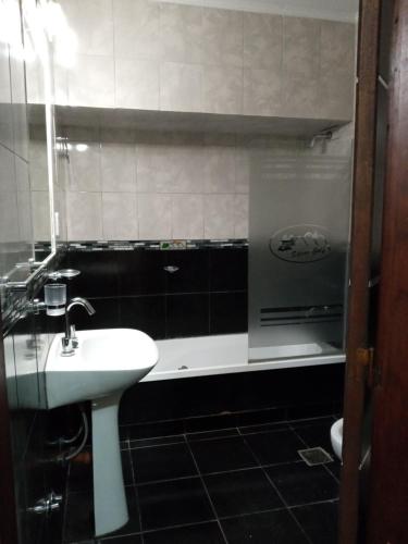 a bathroom with a sink and a bath tub at Hotel Silver Golf in Sierra de la Ventana