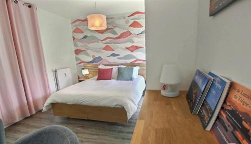 a bedroom with a bed and a painting on the wall at City Bagot in Saint-Brieuc