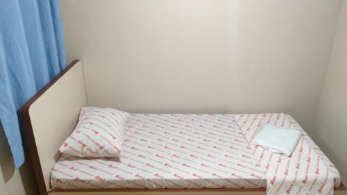 una piccola camera da letto con un letto con un lenzuolo a righe di Hotel Curitiba - São Paulo, próximo a Sta Efigênia, 25 de março, Bom Retiro a San Paolo