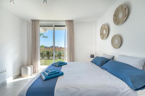 sypialnia z dużym łóżkiem z niebieskimi poduszkami w obiekcie Casa La Cala - Brand new apartment - La Cala de Mijas - Marbella - Malaga area 2 or 3 bedroom w mieście La Cala de Mijas