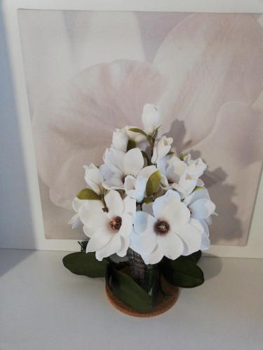 a vase filled with white flowers in front of a painting at B&B LE MAGNOLIE in Gallarate