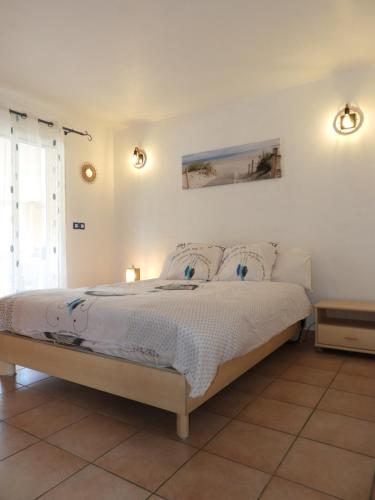 une chambre avec un lit avec des draps blancs et des oreillers dans l'établissement Le lavandin, à Dauphin