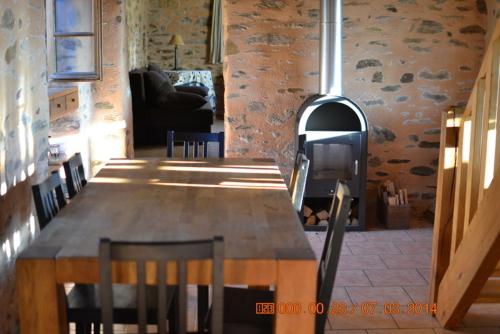 Cette chambre dispose d'une table en bois et d'un poêle à bois. dans l'établissement Clos saint venant, à Payzac