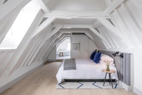 een slaapkamer met een groot bed op een zolder bij Kimpton De Witt Amsterdam, an IHG Hotel in Amsterdam